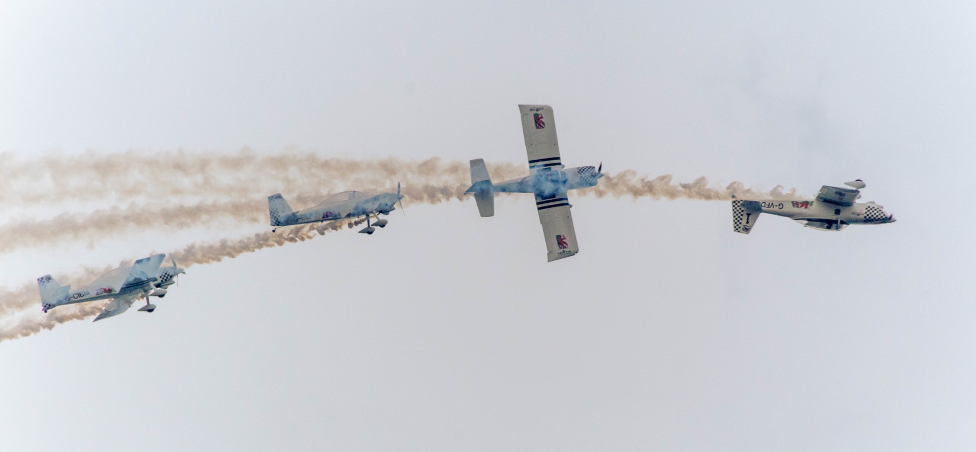 Four airplanes performing a roll at an airshow